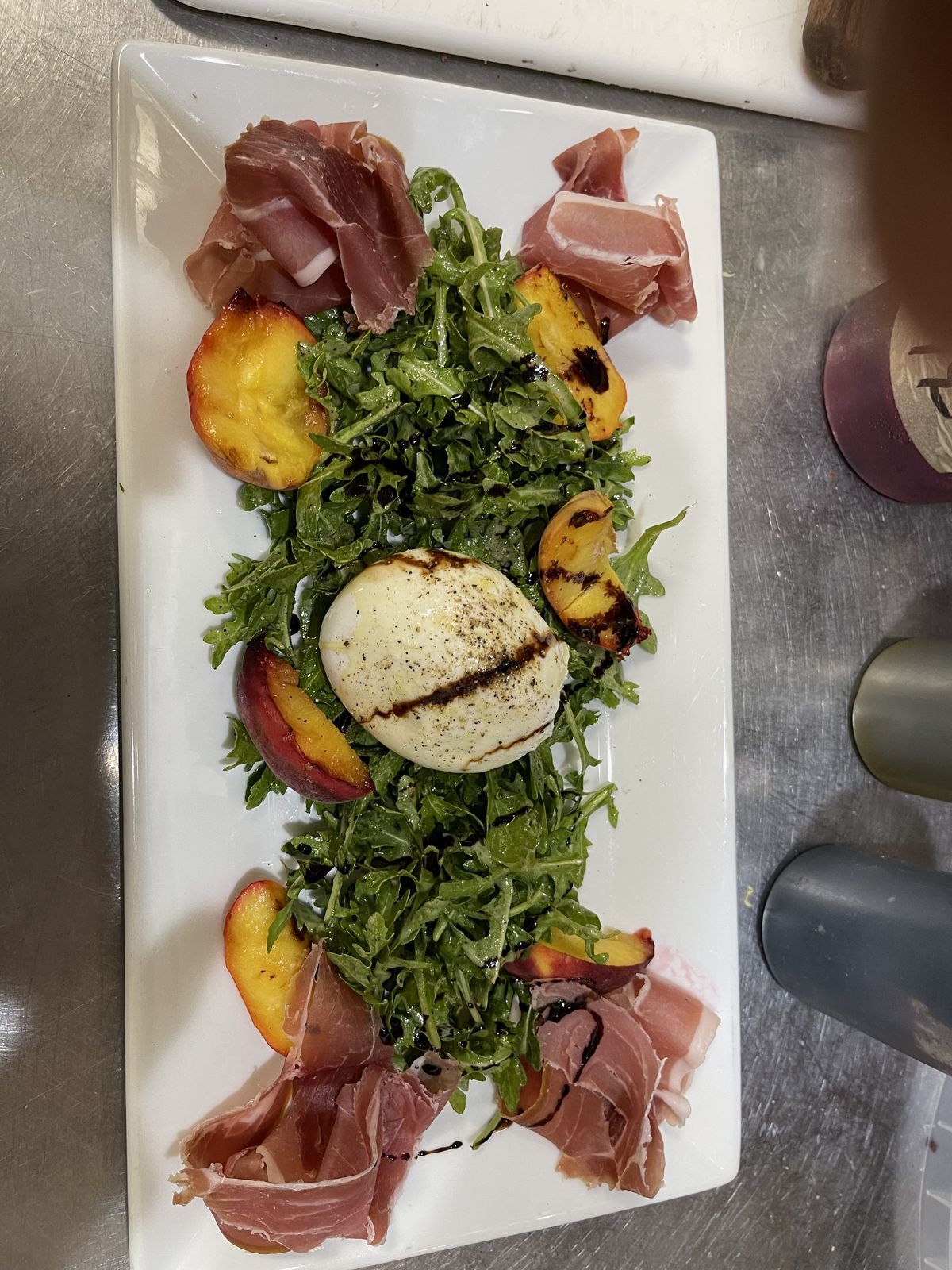Prosciutto, burrata and grilled peaches over arugula