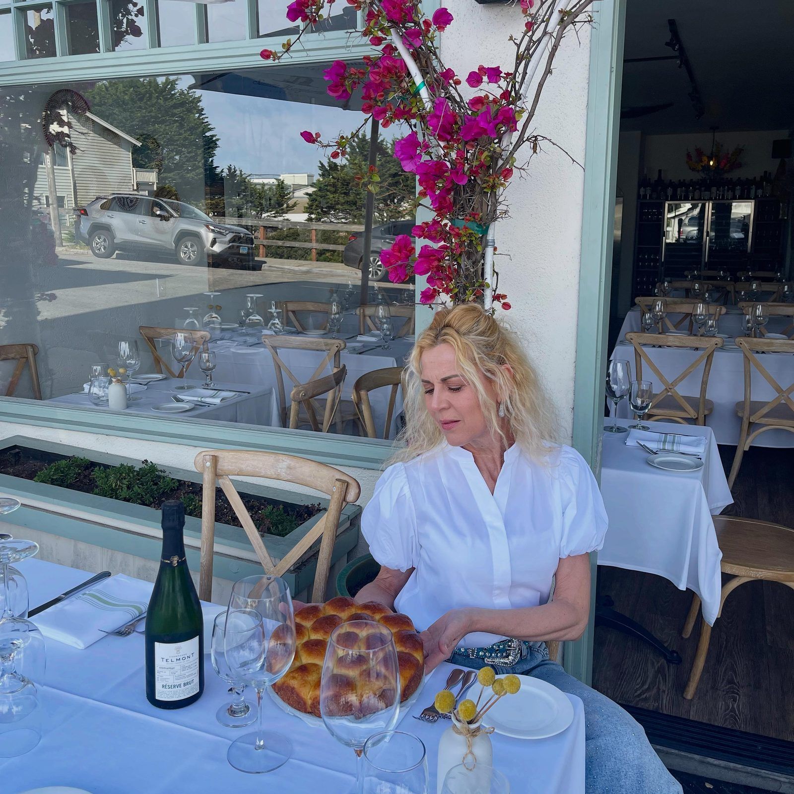 Sabrina Rusciano at a table outside Bistro Moulin, under the bougainvillea